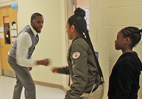 CMS teacher connects to students with special handshakes
